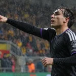 Een Anderlecht-speler viert tijdens een regenachtige Europese wedstrijd.