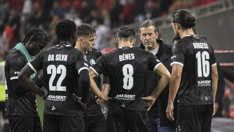 Spelers van KAA Gent verzamelen zich na de wedstrijd rond een staflid langs de zijlijn.