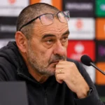 Maurizio Sarri aan een microfoon in een voetbalpersruimte na een wedstrijd.