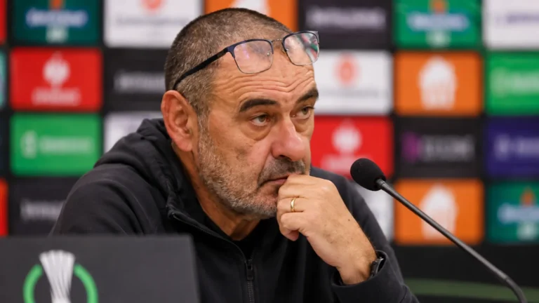 Maurizio Sarri aan een microfoon in een voetbalpersruimte na een wedstrijd.