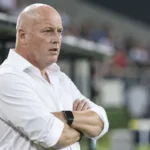 Fred Vanderbiest in wit hemd aan de rand van het veld voor een wedstrijd.