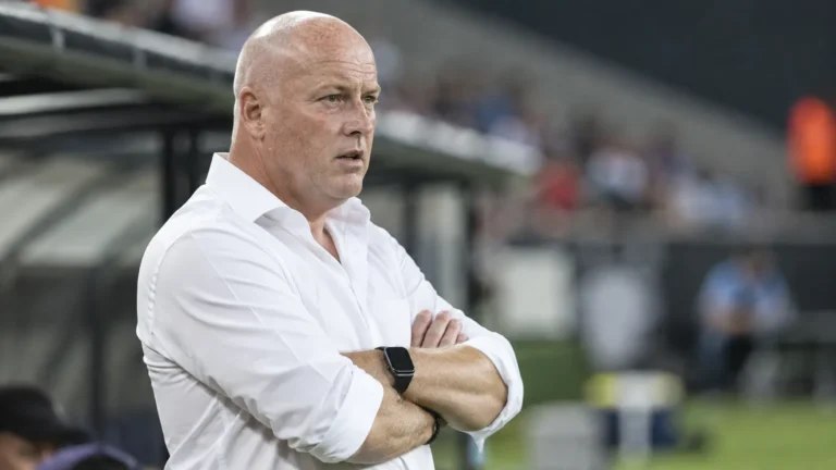 Fred Vanderbiest in wit hemd aan de rand van het veld voor een wedstrijd.