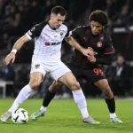Joedrick Pupe van STVV in duel met een speler van Midtjylland.