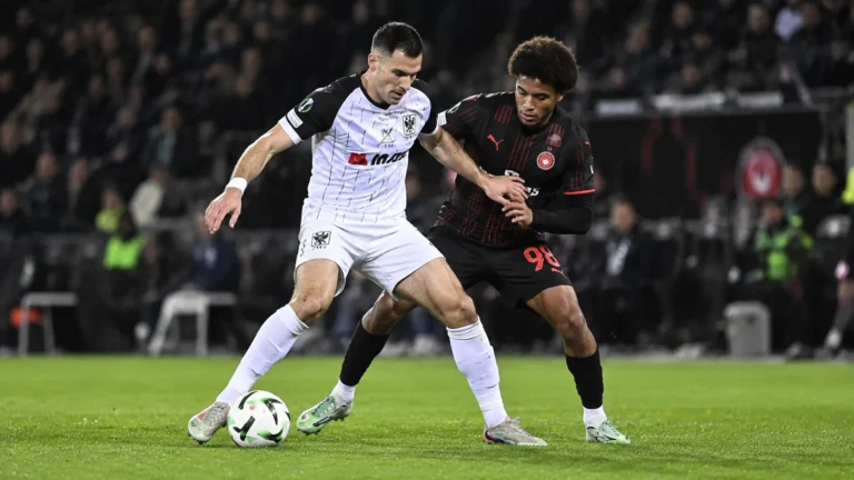 Joedrick Pupe van STVV in duel met een speler van Midtjylland.