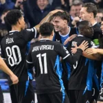 Een groep spelers van Club Brugge viert samen in zwart-blauwe wedstrijdtenues.