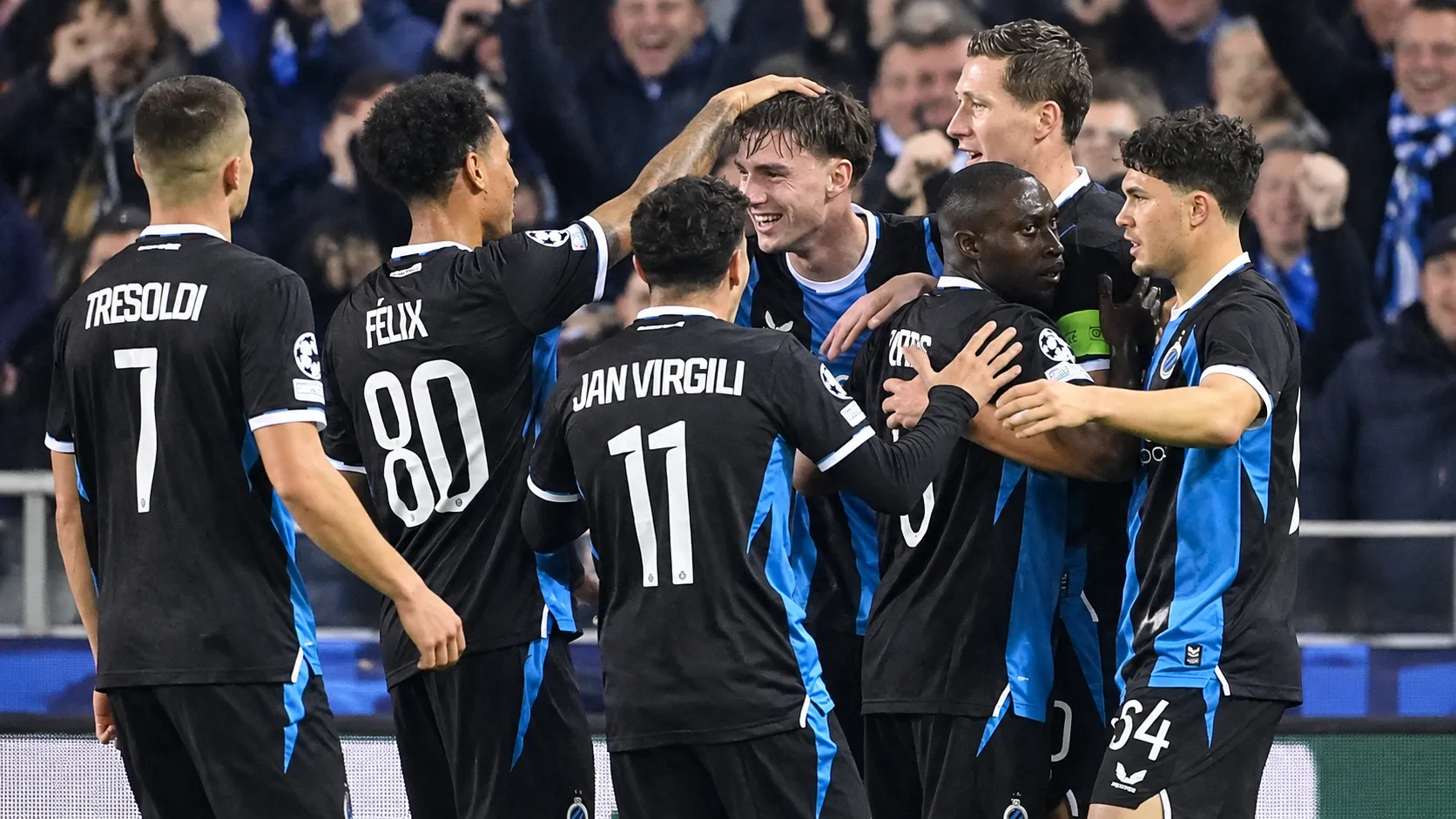 Een groep spelers van Club Brugge viert samen in zwart-blauwe wedstrijdtenues.