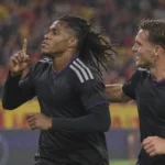 Twee Anderlecht-spelers in donkere wedstrijdkleding vieren samen een moment tijdens een Europese wedstrijd.