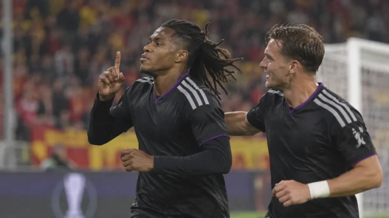 Twee Anderlecht-spelers in donkere wedstrijdkleding vieren samen een moment tijdens een Europese wedstrijd.