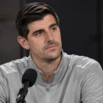 Thibaut Courtois luistert aandachtig tijdens een voetbalinterview in een neutrale studio.
