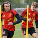 Twee spelers van de Rode Duivels trainen tussen gele slalompalen.