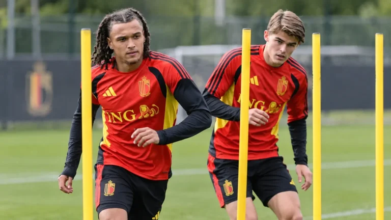 Twee spelers van de Rode Duivels trainen tussen gele slalompalen.