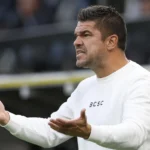 Mario Kohnen reageert langs de zijlijn in een witte trui.