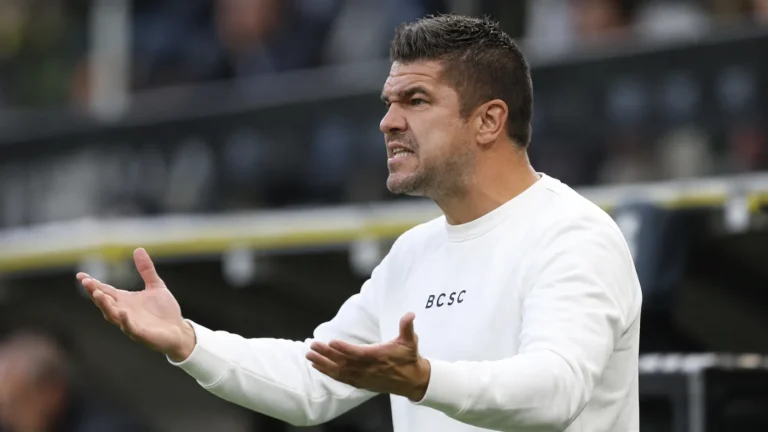 Mario Kohnen reageert langs de zijlijn in een witte trui.
