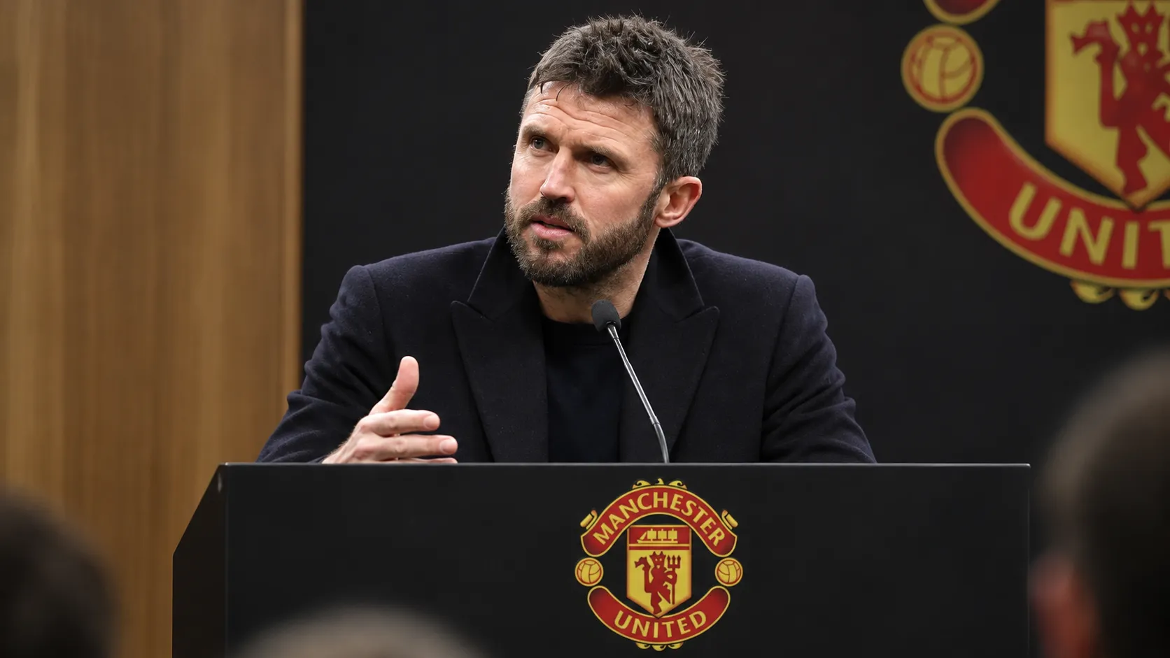 Michael Carrick spreekt aan een lessenaar tijdens een persmoment van Manchester United.