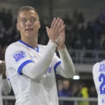 Daan Heymans applaudisseert in het witte tenue van KRC Genk na een wedstrijd.