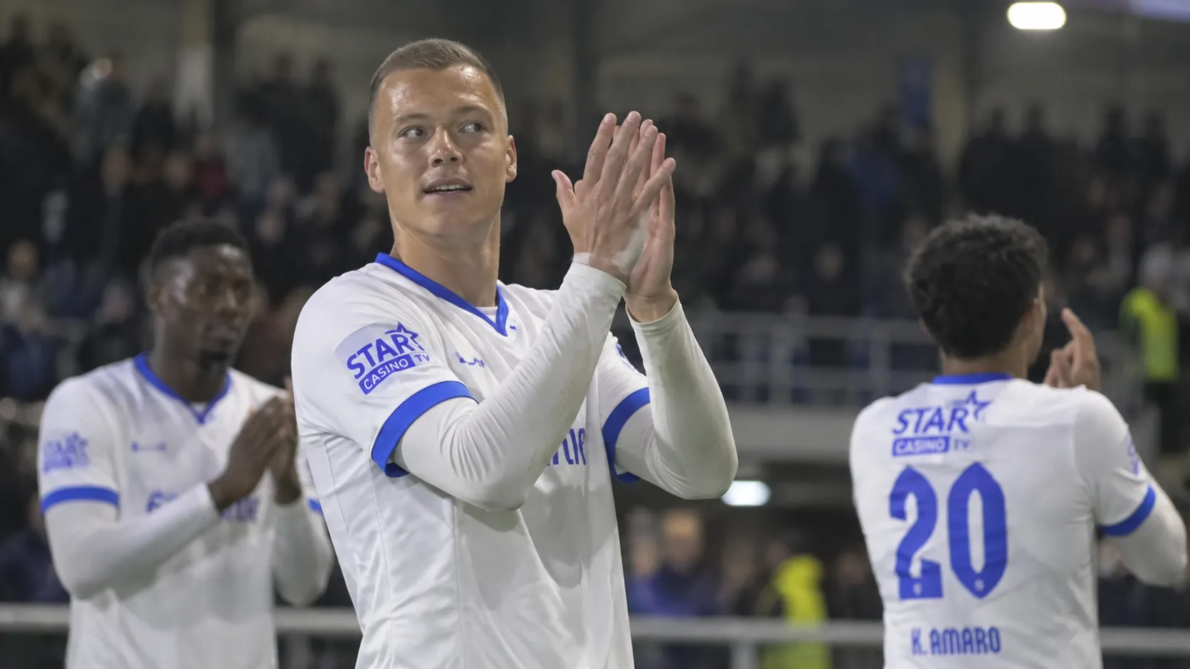 Daan Heymans applaudisseert in het witte tenue van KRC Genk na een wedstrijd.