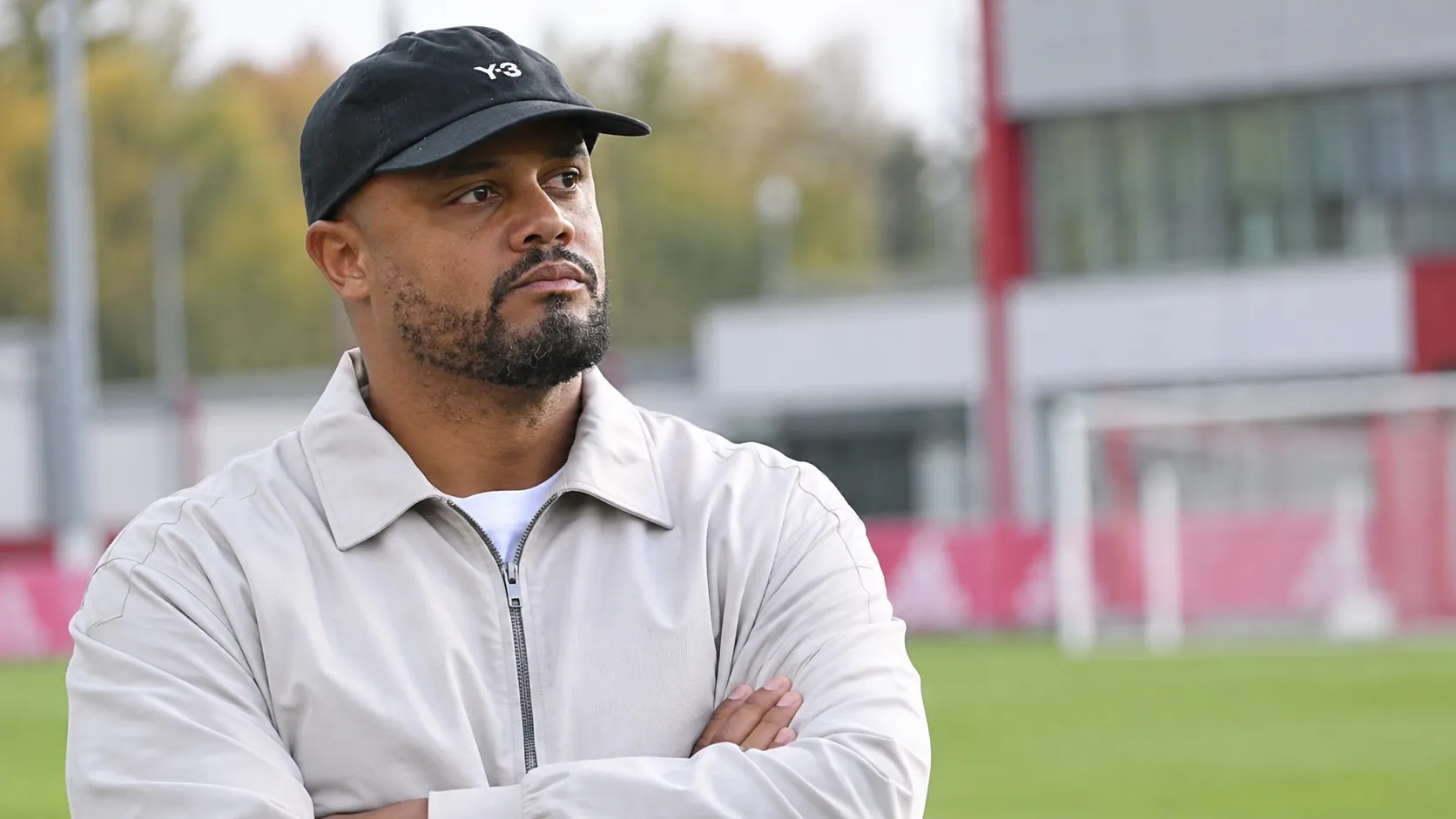 Vincent Kompany in een zwarte pet en lichte jas op het trainingscomplex van Bayern München.