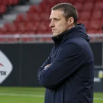 Timmy Simons kijkt vanaf de zijlijn naar de opwarming in het stadion van OH Leuven.
