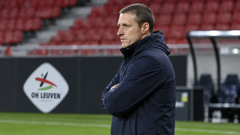 Timmy Simons kijkt vanaf de zijlijn naar de opwarming in het stadion van OH Leuven.