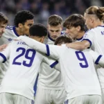 Anderlecht-spelers overleggen in een kring op het veld.