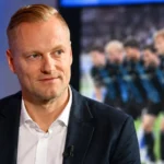 Olivier Deschacht in een donkere blazer in een rustige studiocontext.
