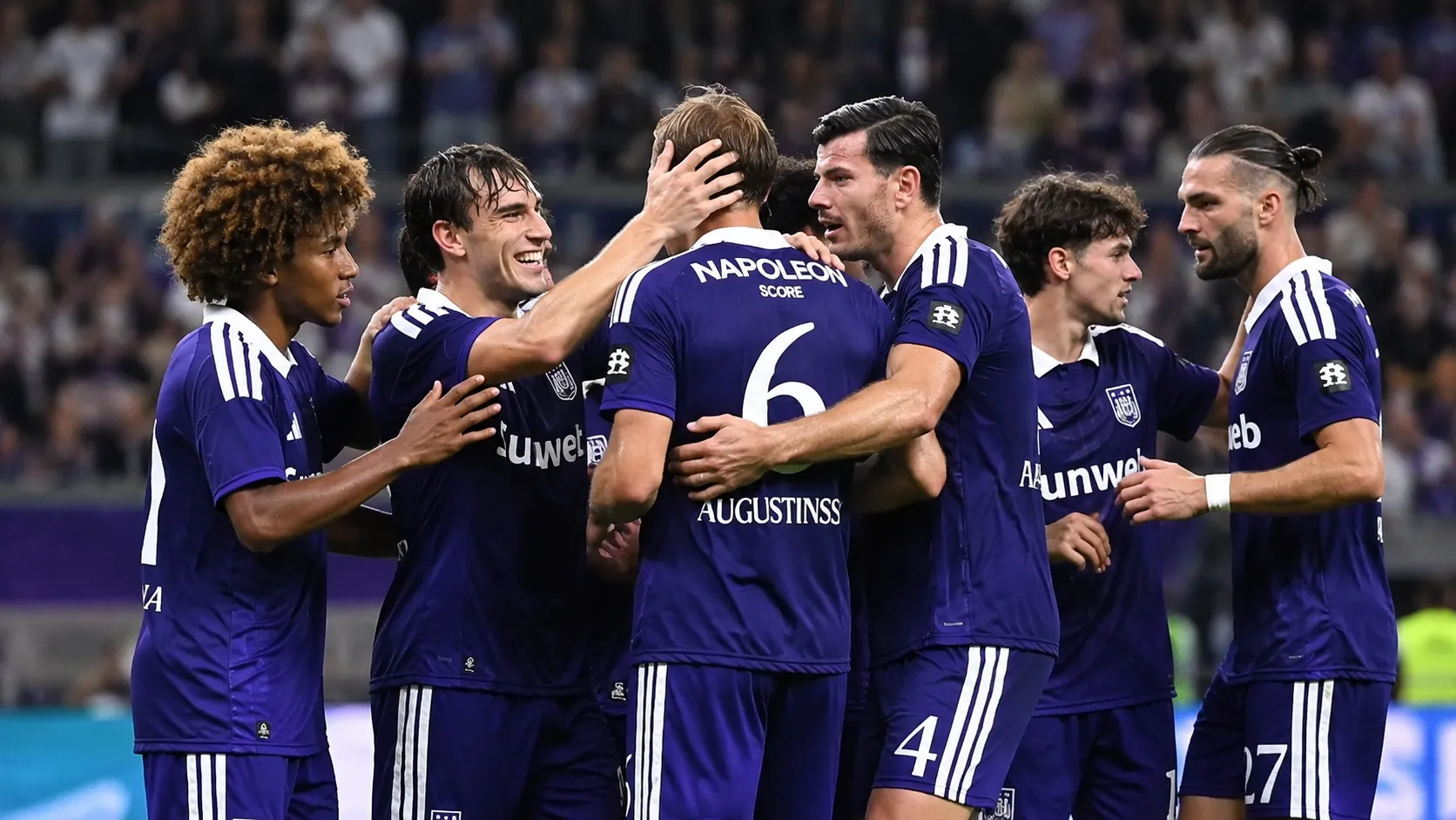 Een groep Anderlecht-spelers viert samen op het veld in paarse wedstrijdtenues.