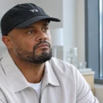 Vincent Kompany zit rustig in een lichte ziekenhuiskamer.