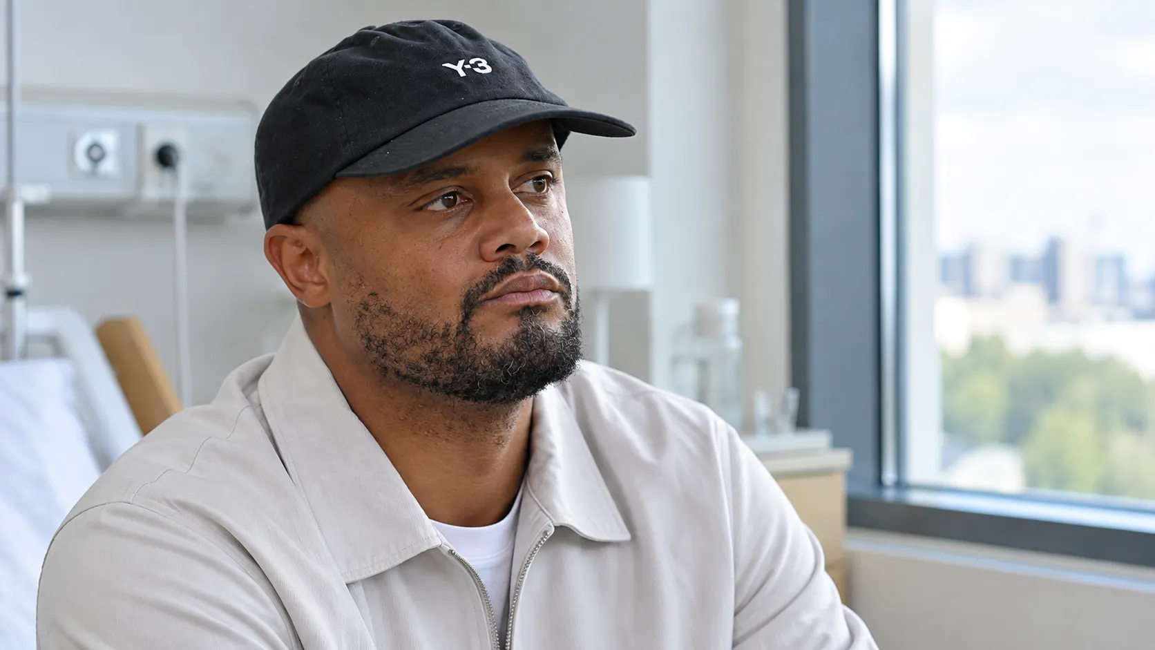 Vincent Kompany zit rustig in een lichte ziekenhuiskamer.