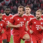 Een groep Bayern-spelers in rode wedstrijdtenues tijdens een gezamenlijke opwarming.