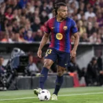 Jules Koundé in het shirt van FC Barcelona aan de rand van het veld.