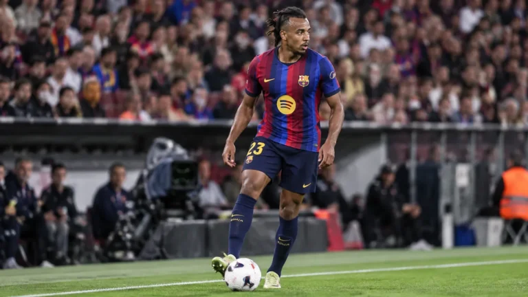 Jules Koundé in het shirt van FC Barcelona aan de rand van het veld.