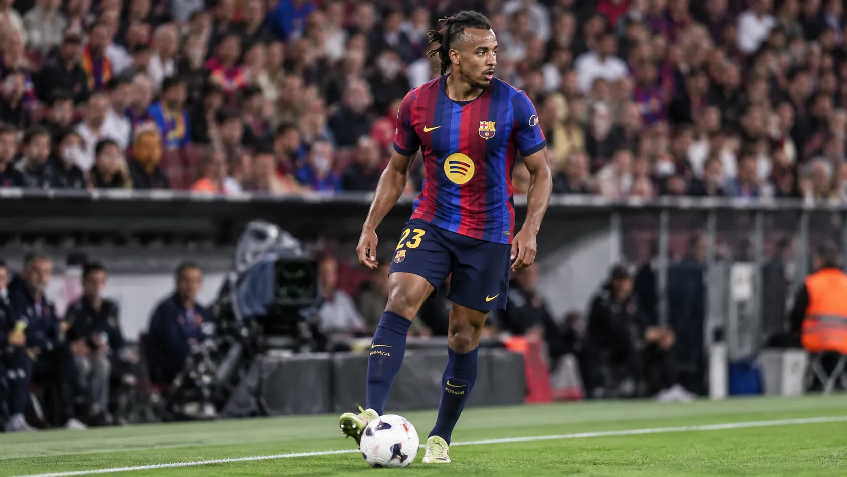 Jules Koundé in het shirt van FC Barcelona aan de rand van het veld.