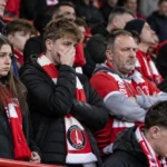 Teleurgestelde Charlton Athletic-supporters met rood-witte sjaals op de thuistribune.