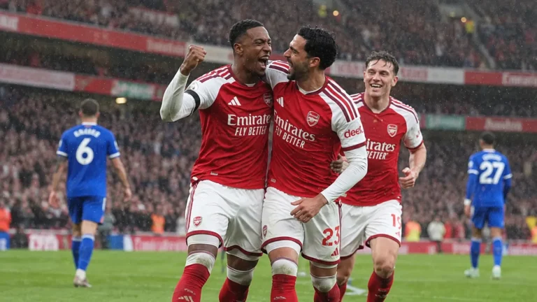 Arsenal-spelers vieren samen tijdens een wedstrijd in de regen.