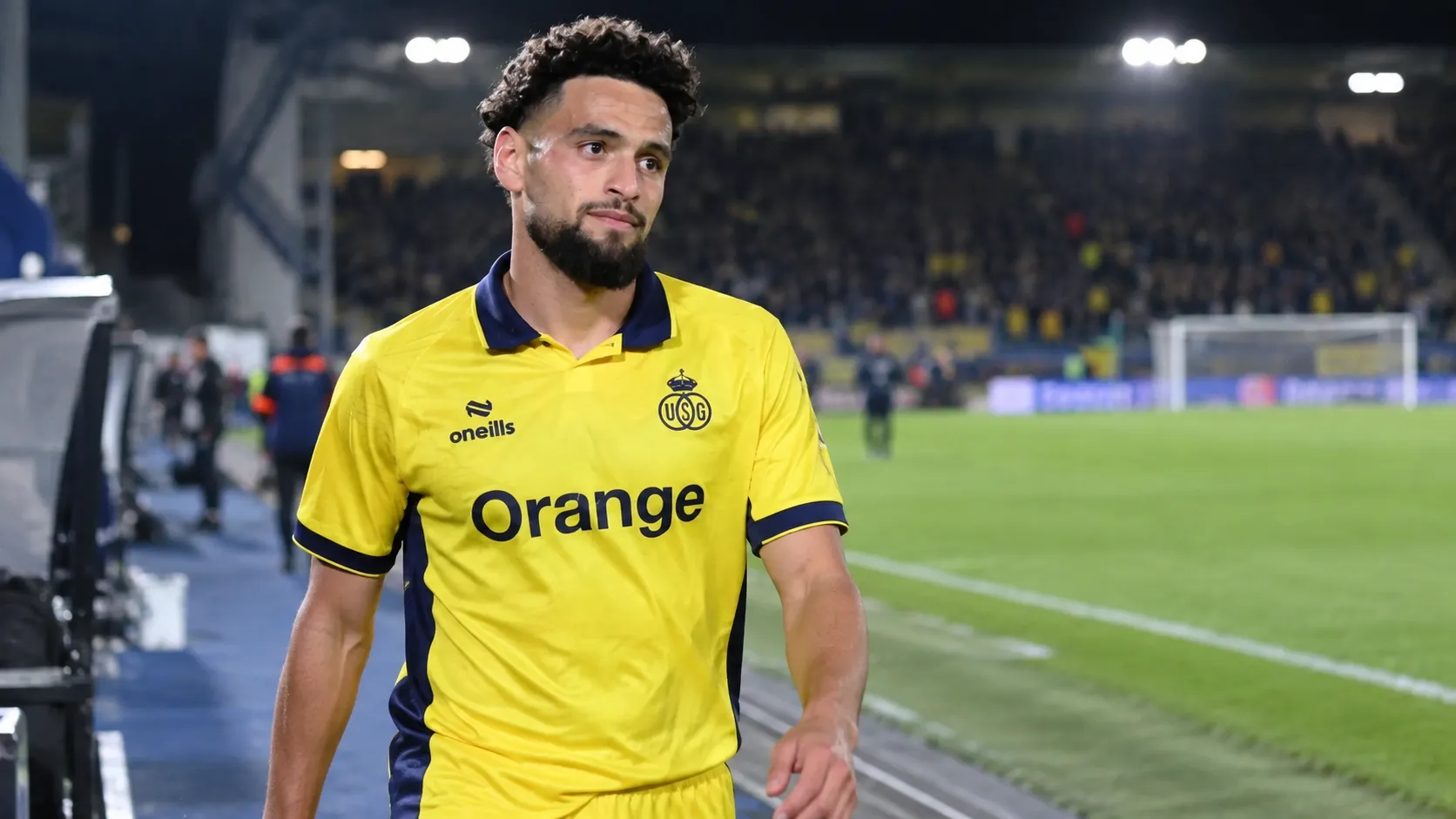 Adem Zorgane in het gele shirt van Union Saint-Gilloise langs de zijlijn na een wedstrijd.