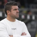 Een medewerker van Charleroi reageert langs de zijlijn in een stadion.