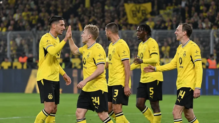 Dortmund-spelers in geel vieren samen een moment op het veld.