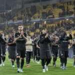 Een groep Anderlecht-spelers en stafleden applaudisseert voor de tribunes na een Europese wedstrijd.