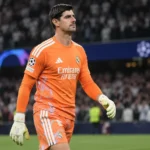 Thibaut Courtois in het oranje doelmanstenue van Real Madrid op het veld na een wedstrijd.
