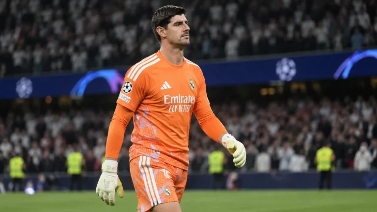 Thibaut Courtois in het oranje doelmanstenue van Real Madrid op het veld na een wedstrijd.