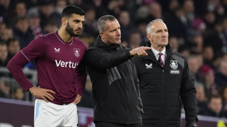 Een Burnley-speler naast twee leden van de staf aan de zijlijn.