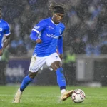 Noah Adedeji-Sternberg van KRC Genk controleert de bal tijdens een regenachtige wedstrijd.