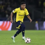 Relebohile Mofokeng in geel Union-tenue tijdens een voetbalactie met de bal.