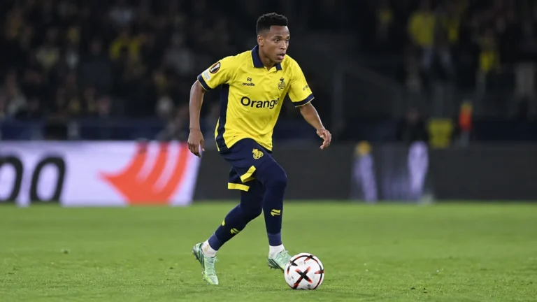 Relebohile Mofokeng in geel Union-tenue tijdens een voetbalactie met de bal.
