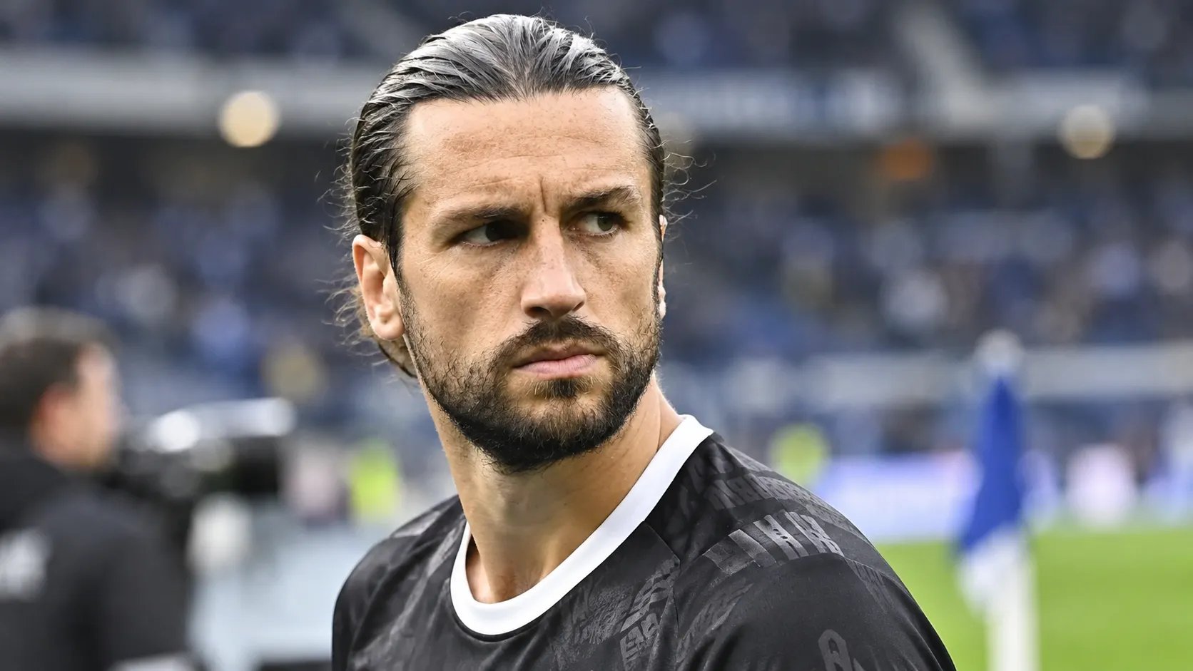 Christian Burgess van KAA Gent kijkt geconcentreerd langs de rand van het veld.