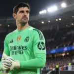 Thibaut Courtois in het groene doelmanstenue van Real Madrid aan de rand van het stadion.