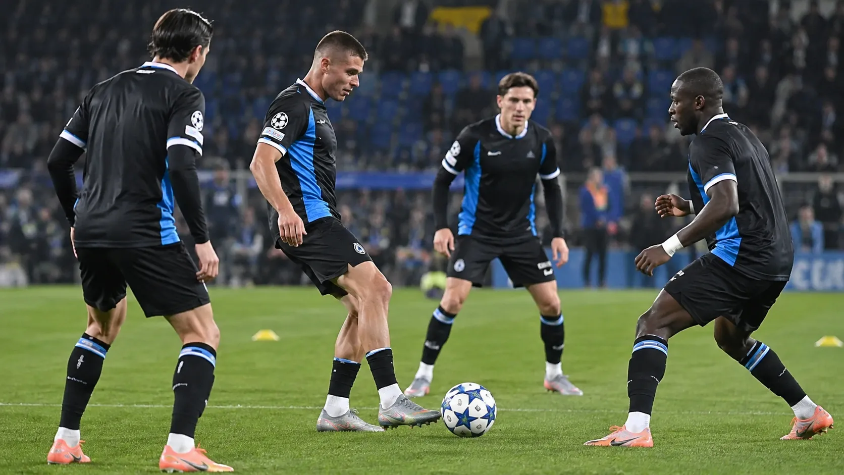 Een groep Club Brugge-spelers warmt op het veld op voor een thuiswedstrijd.
