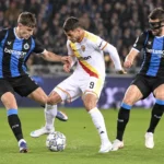Voetballers van Club Brugge in een defensief duel tijdens een avondwedstrijd.