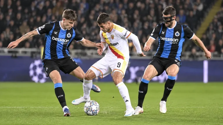 Voetballers van Club Brugge in een defensief duel tijdens een avondwedstrijd.
