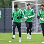 Vier doelmannen van de Rode Duivels tijdens een opwarming op het trainingsveld.